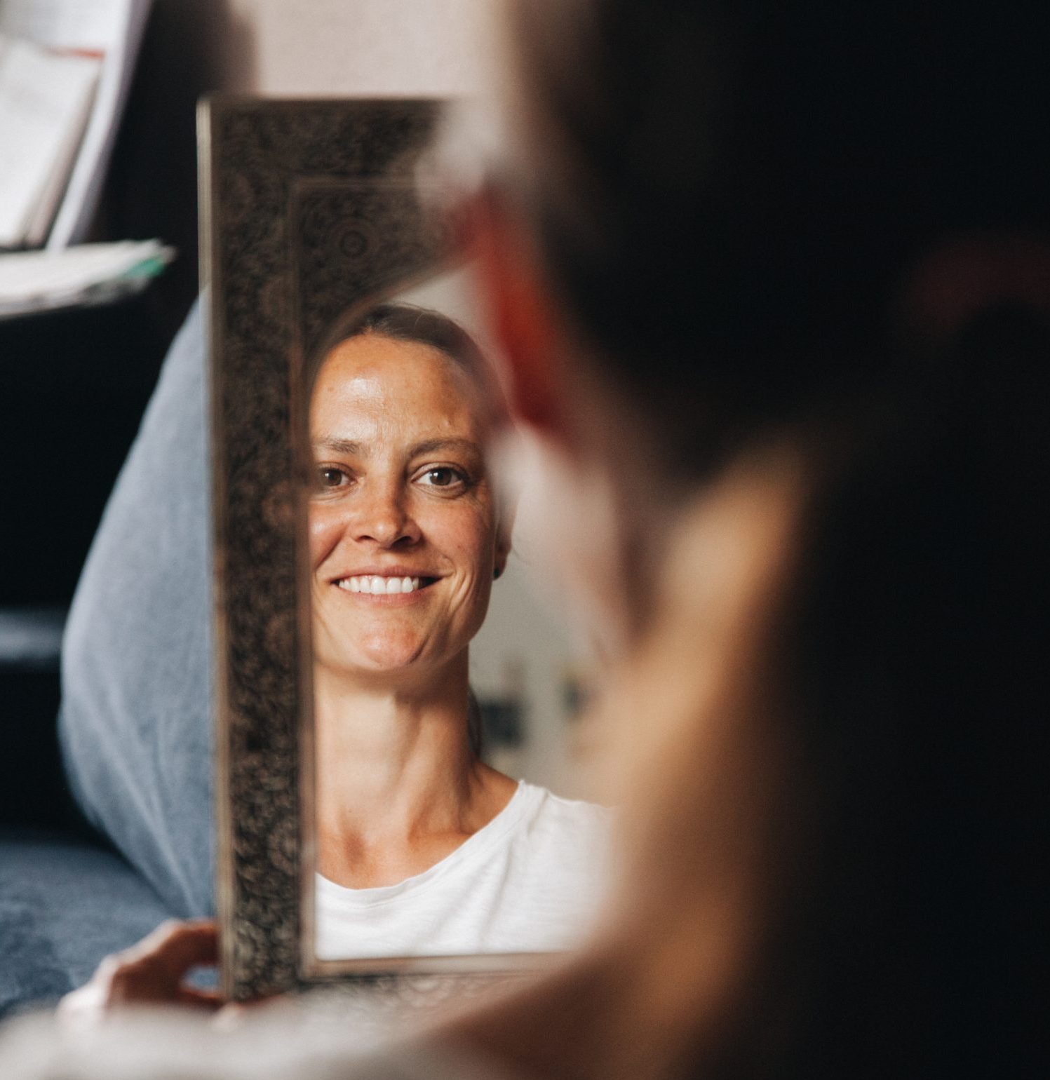 Kundin schaut in den Spiegel und lächelt